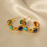 Close-up of classic retro gold earrings with curved hoop and stones